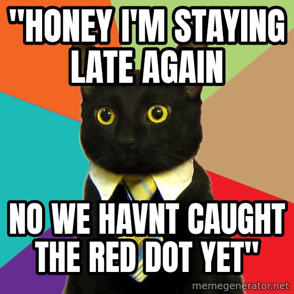 Business Cat meme: "honey I'm staying late again / no we havnt caught the red dot yet"